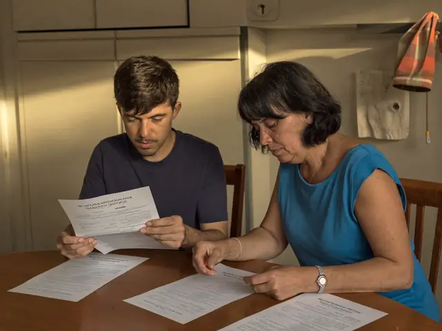 Mãe e filho adulto lendo documentos de seguro na mesa da cozinha